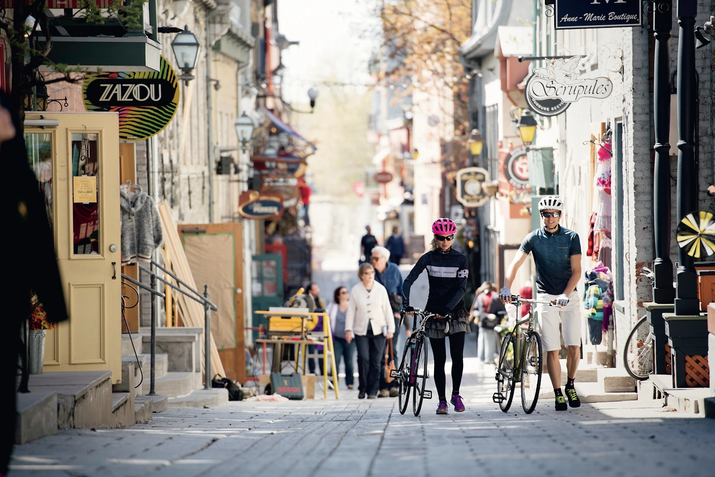 ケベックの街を自転車とともに歩く人々